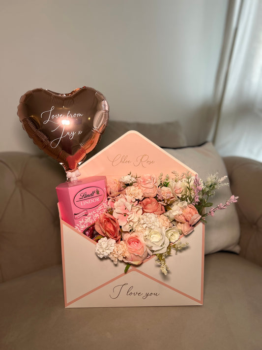 Pink and white envelope with flowers chocolate and balloon