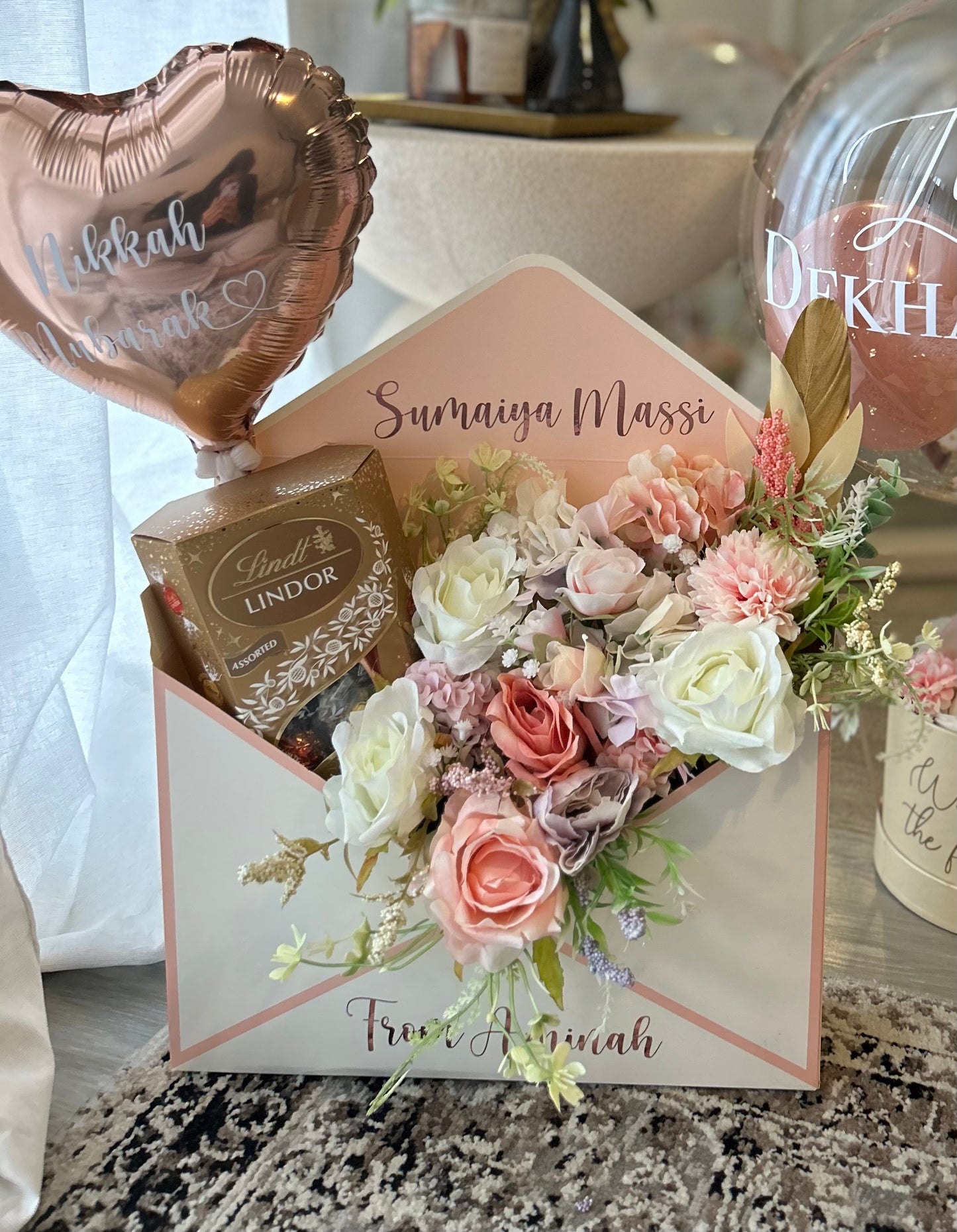 Pink and white envelope with flowers chocolate and balloon